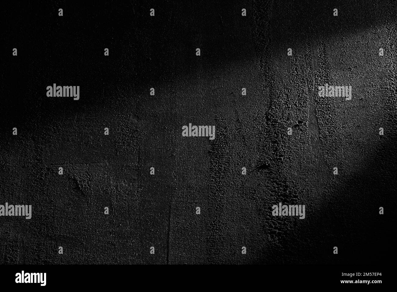 Black wall rough texture background, concrete floor or old grunge backdrop, illuminated by sun ray. Close up of dark graphite surface for modern background design. Concept of textures and background. Stock Photo