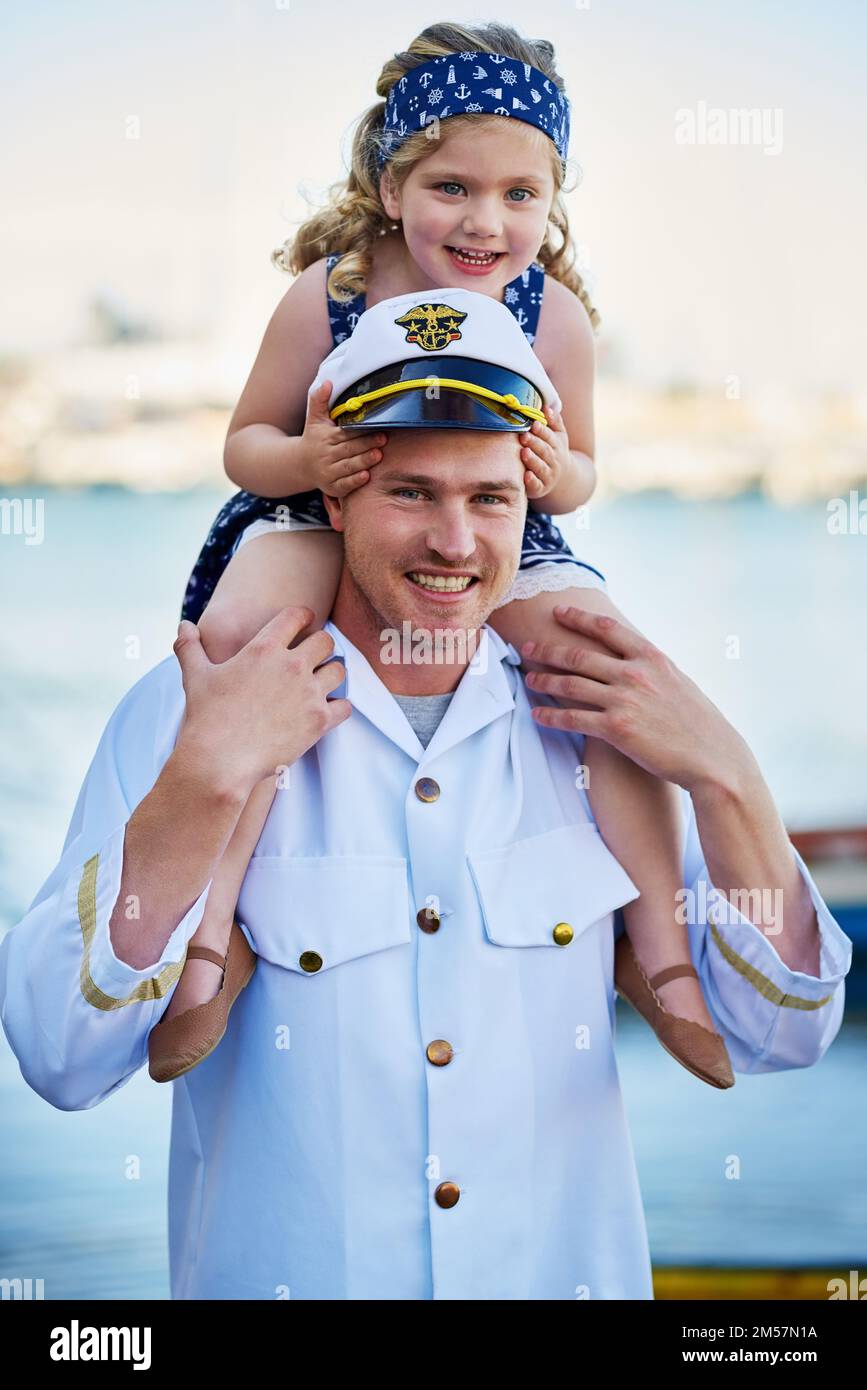 Shes got me wrapped around her finger. Portrait of a father in a navy uniform carrying his little girl on his shoulders. Stock Photo