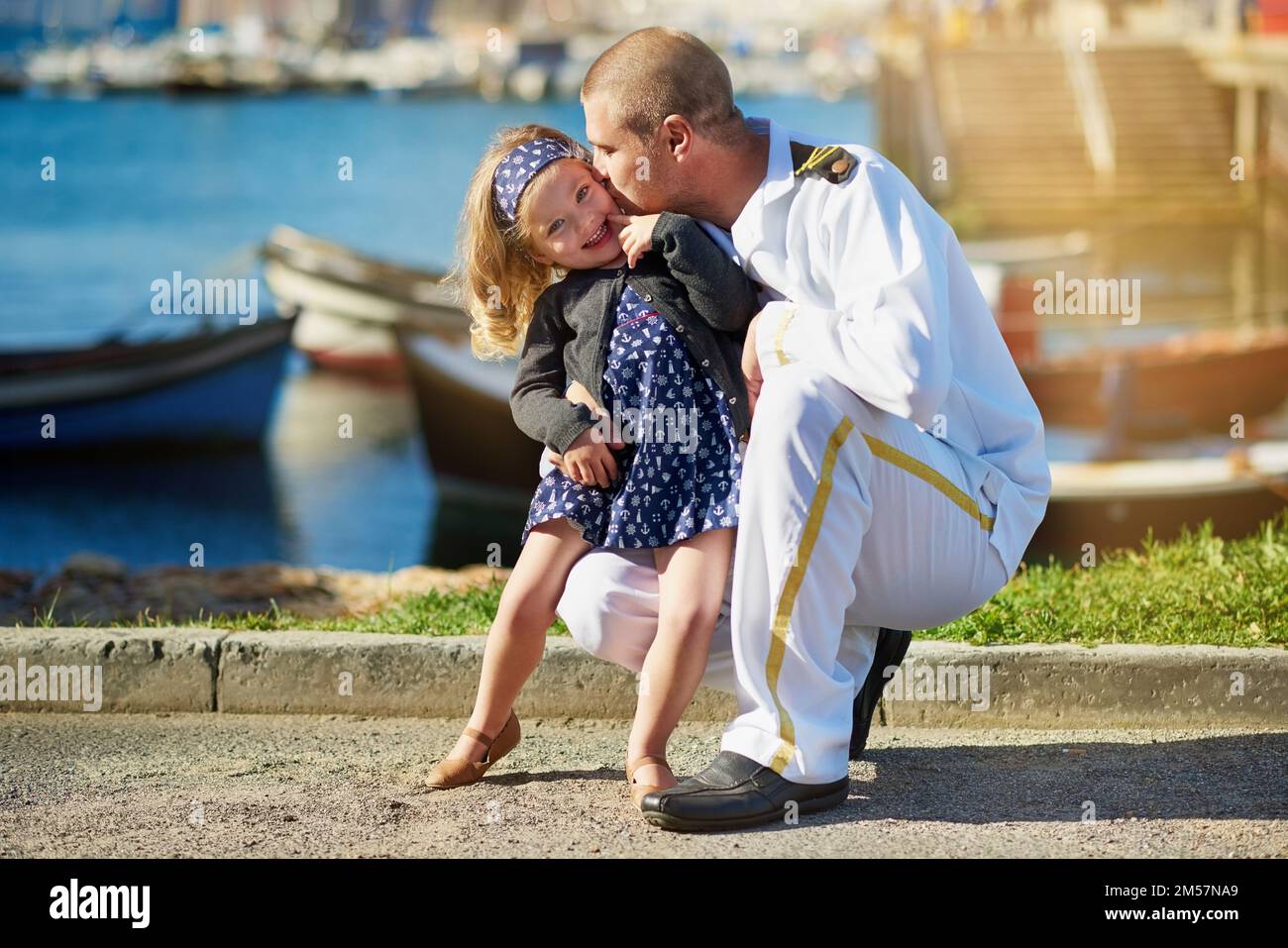 Youll always be my little girl. Portrait of a father in a navy uniform posing with his little girl on the dock. Stock Photo