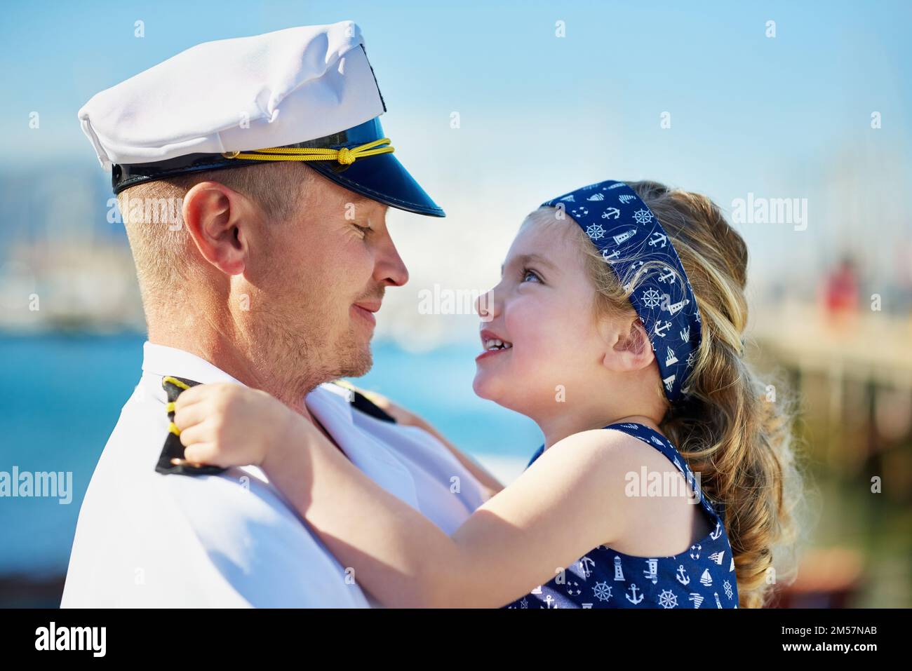 Her father is her hero. a father in a navy uniform bonding with his little girl on the dock. Stock Photo