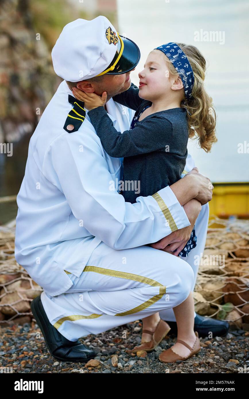 Every father is his daughters first love. a father in a navy uniform bonding with his little girl on the dock. Stock Photo