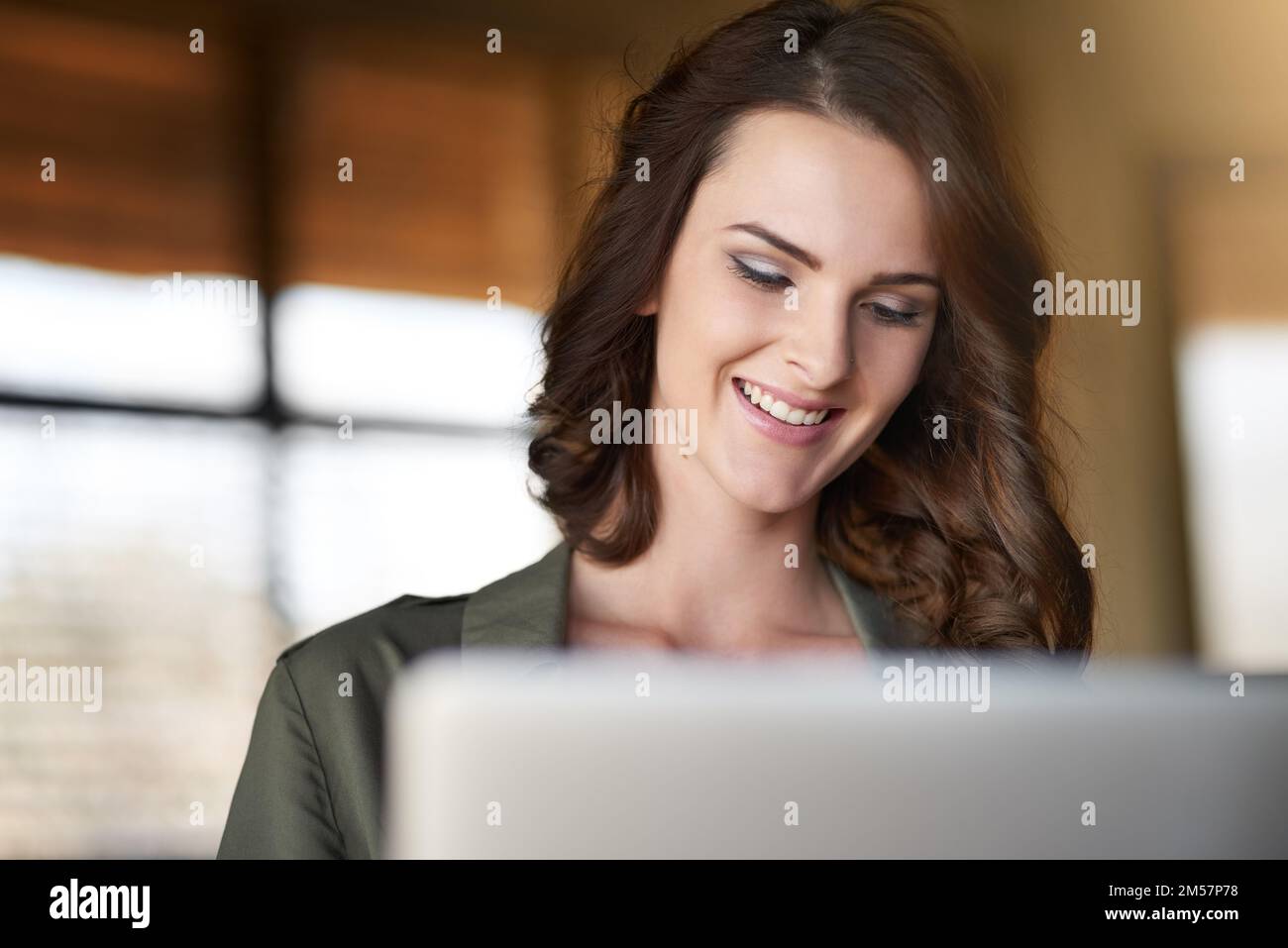 If theres wifi, Im happy. a happy young woman blogging on her laptop. Stock Photo