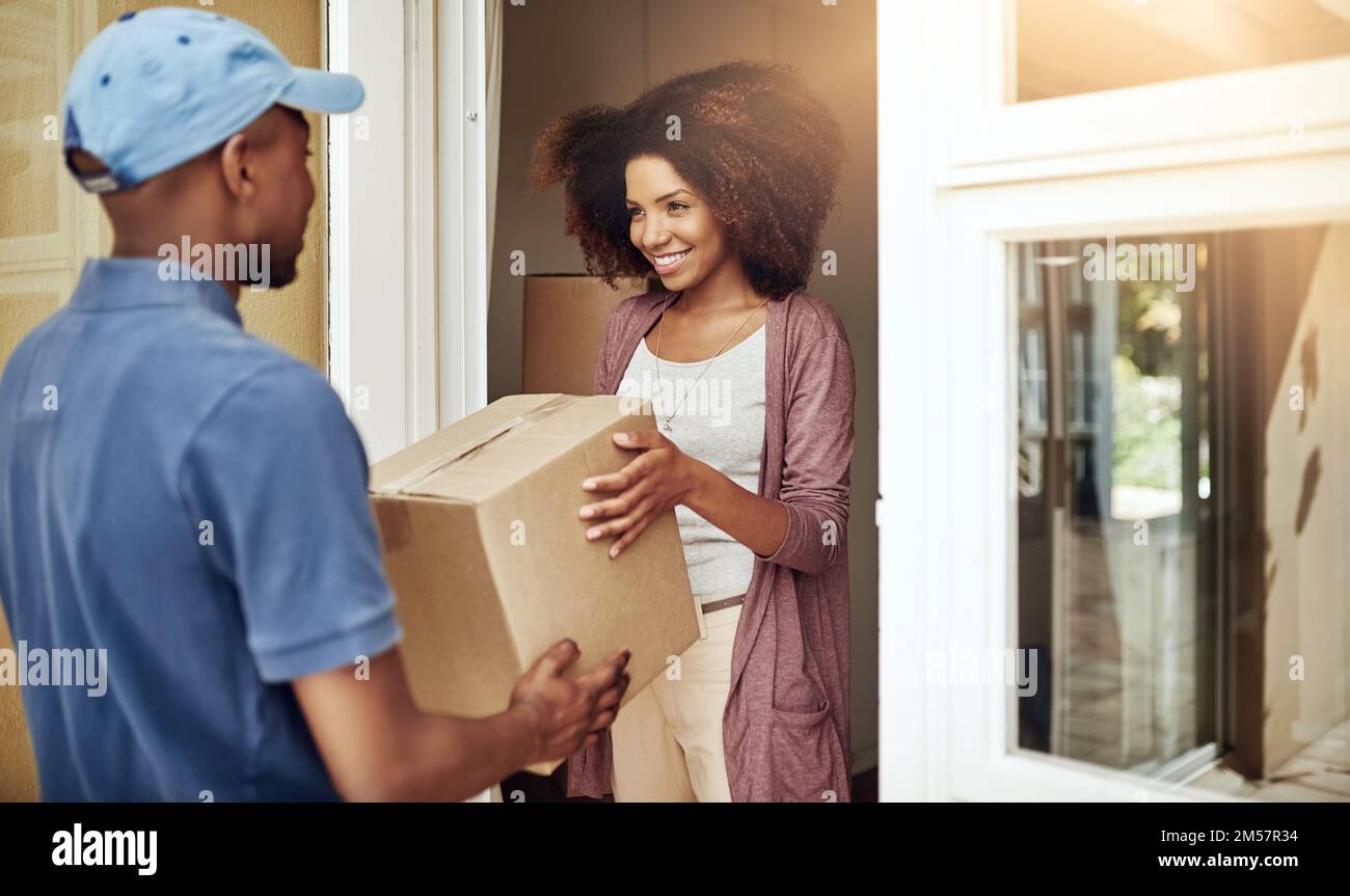 Door to door delivery. a postal worker delivering a package to a young