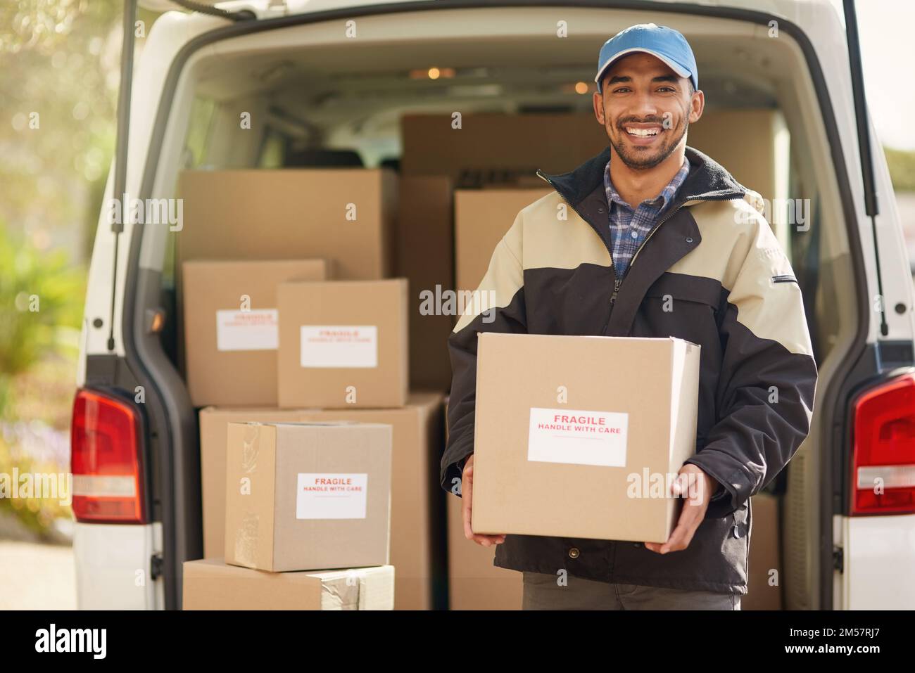 Getting packages on their way. Portrait of a smiling delivery man standing in front of his van