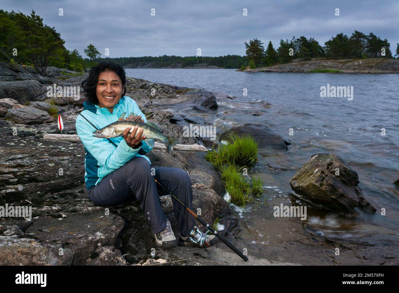Girl with a Zander, Sander lucioperca, at the island Gudøya in the lake Vansjø, Norway. Vansjø is a part of the water system called Morsavassdraget. Stock Photo