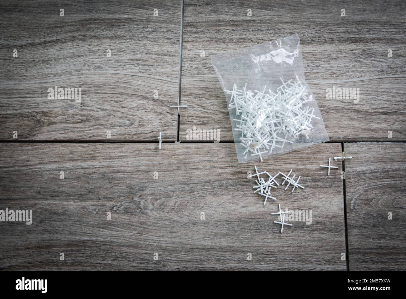 Laying ceramic tiles using plastic crosses. Packaging on the floor. Renovation or repair concept. Stock Photo
