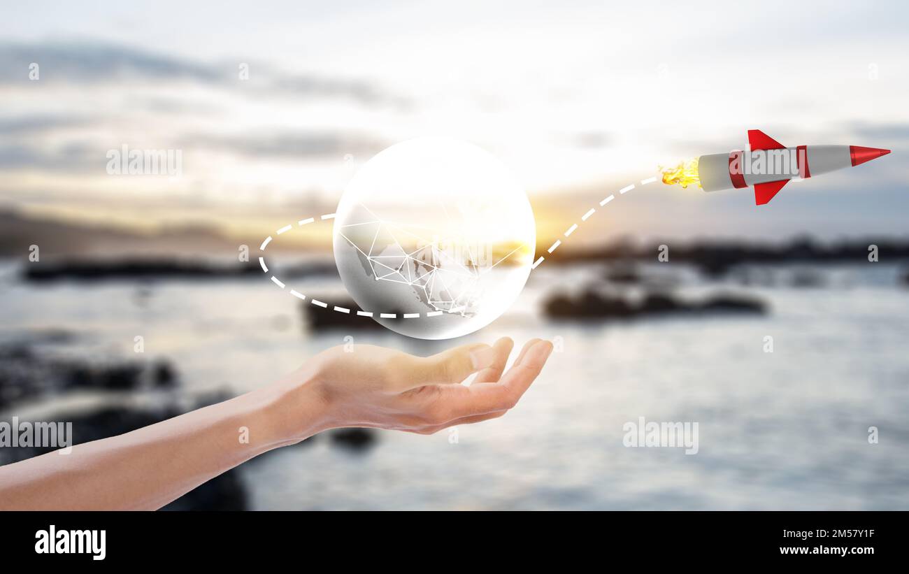 Human hand showing a virtual globe with a flying rocket. National Science Day Stock Photo