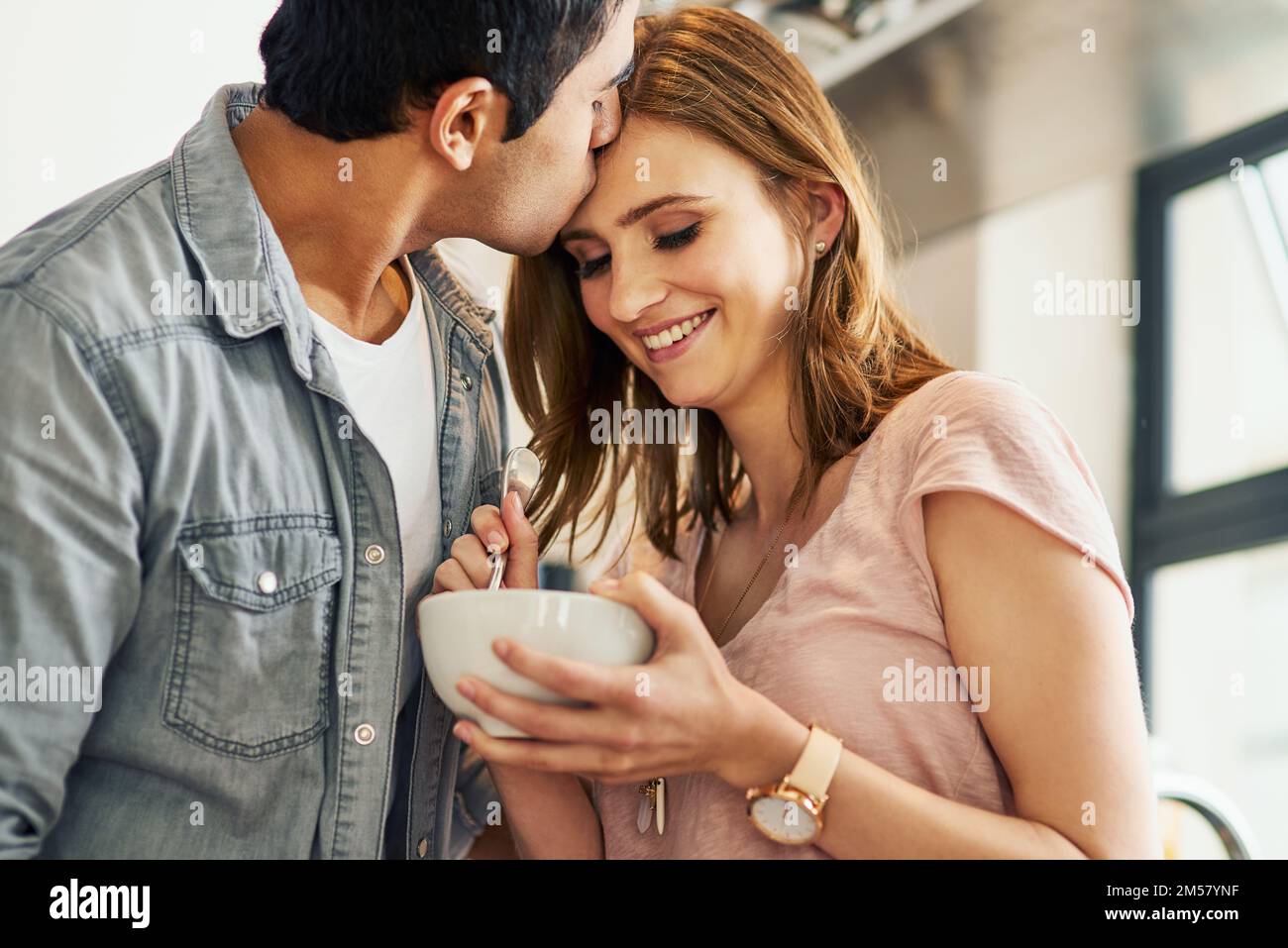 Young and in love. an affectionate young couple standing in their kitchen. Stock Photo