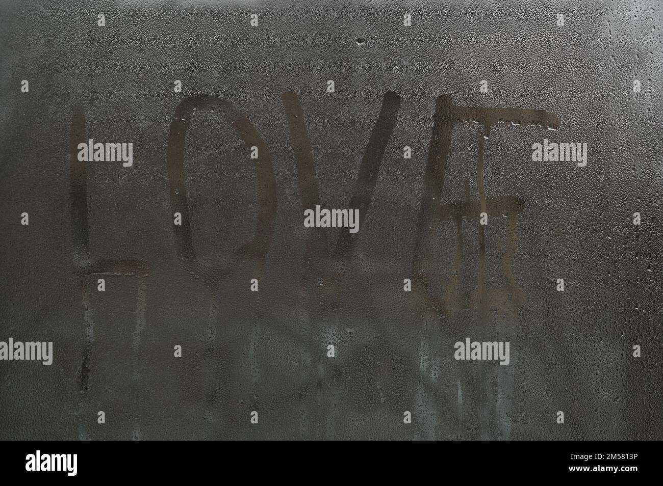 the word love on wet glass. Condensation on window Stock Photo