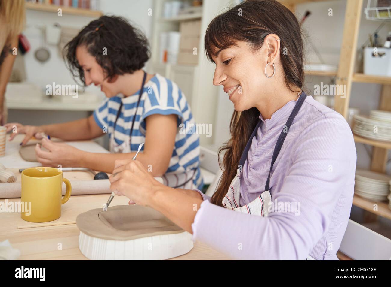 Women making handmade pottery in a pottery class. Handicraft and