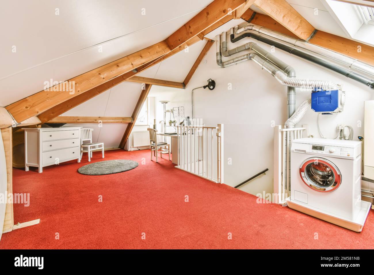 a laundry room with red carpet and white washer in the corner on the