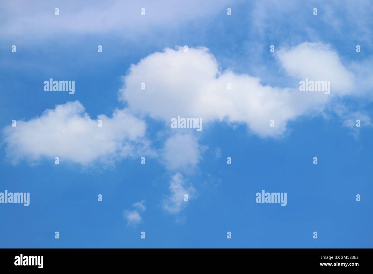 White Fluffy Clouds Floating on Bright Blue Sky Stock Photo