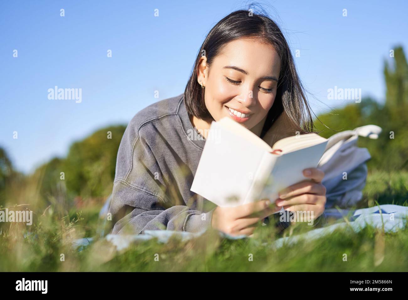 A pretty middle age Korean woman with a pleasent smile in a park