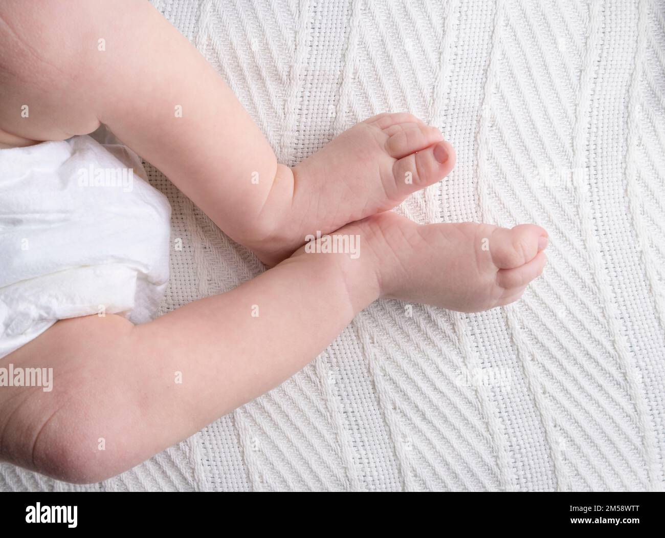 legs of a baby or a newborn child on a light background closeup Stock
