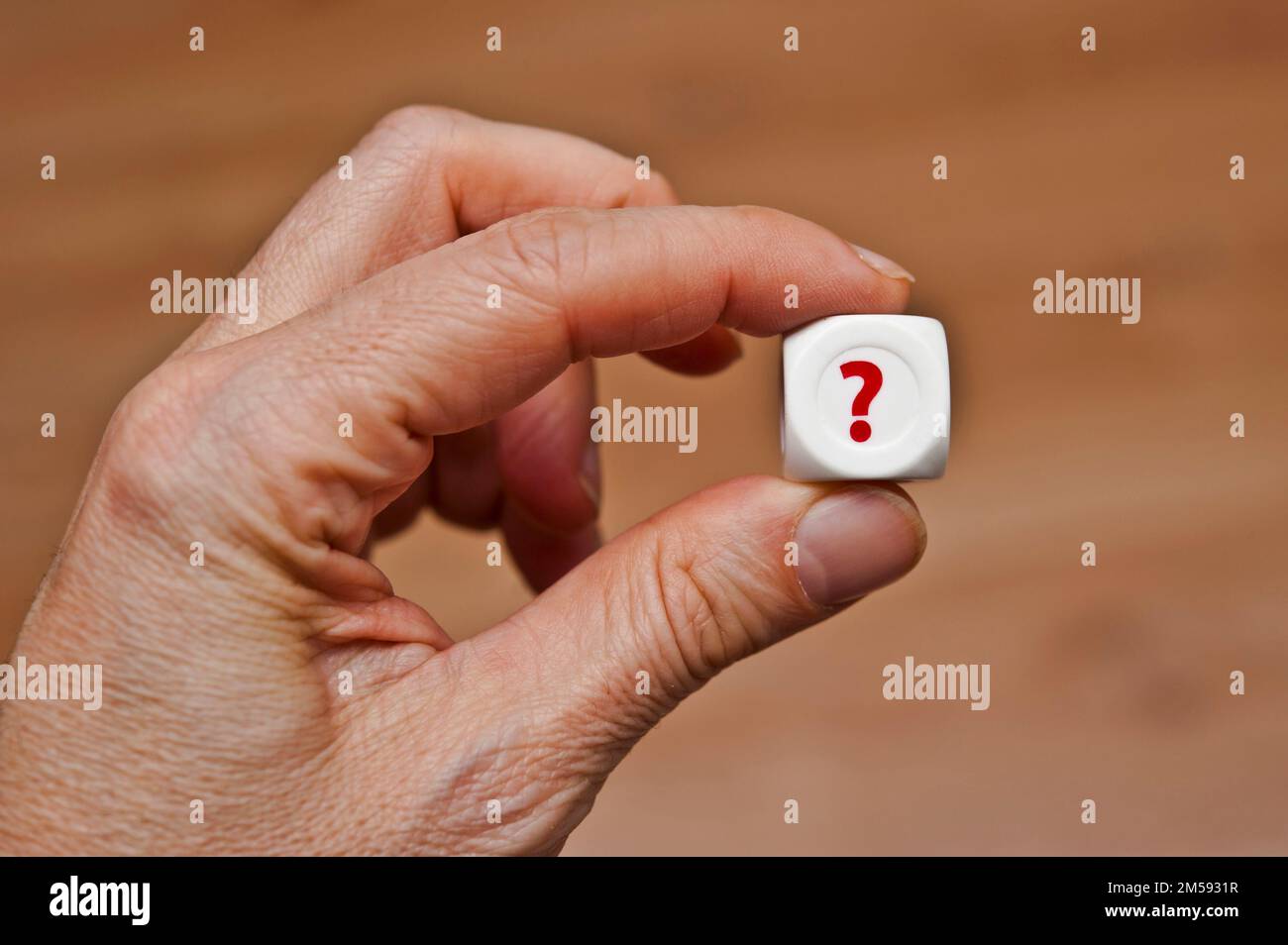 hand holding a dice with question mark Stock Photo