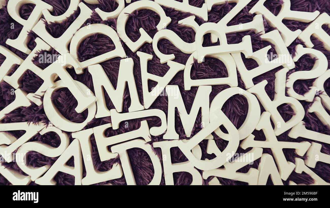 Random Letters White random white wooden alphabet letters top view on purple background ...