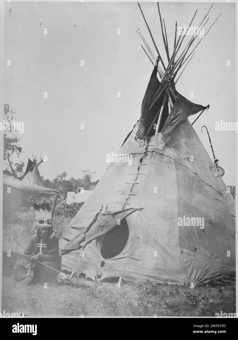 Little Big Mouth, a Medicine Man, Seated in front of his Lodge near Fort Sill, Oklahoma, with Medicine Bag Visible from behind the Tent. Arapaho(?) or Cheyenne(?) medicine man, near Ft. Sill (pencil notation reads 'Little Big Mouth' (?), Soule'). 1870-01-01T00:00:00. National Archives at College Park - Archives II (College Park, MD). Negative. Department of the Interior. Office of Indian Affairs. 1849-9/17/1947. William S. Soule Photographs of Arapaho, Cheyenna, Kiowa, Comanche, and Apache Indians Stock Photo