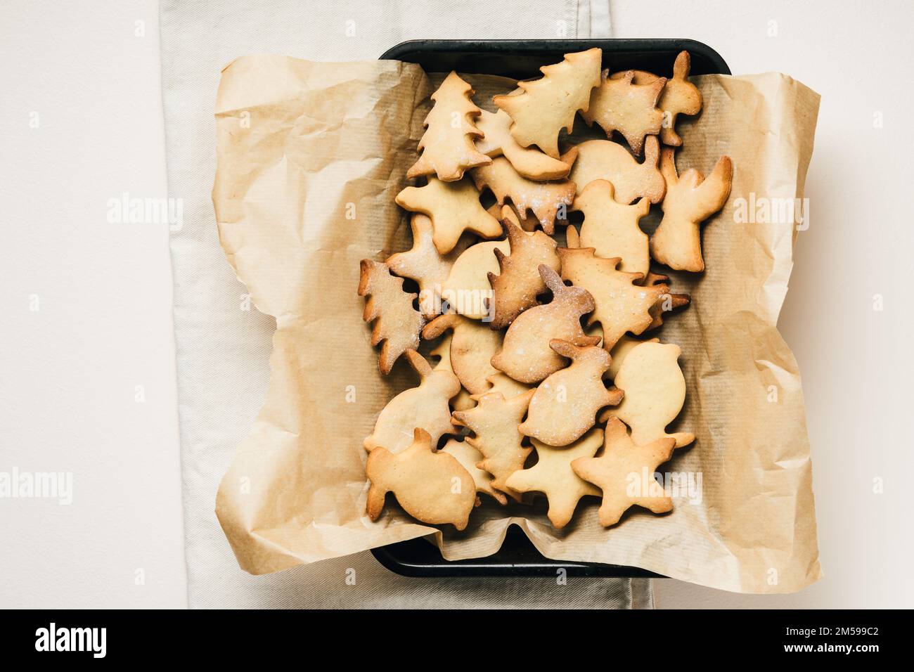 Pile of Christmas-themed gingerbread cookies on baking tray. Stock Photo