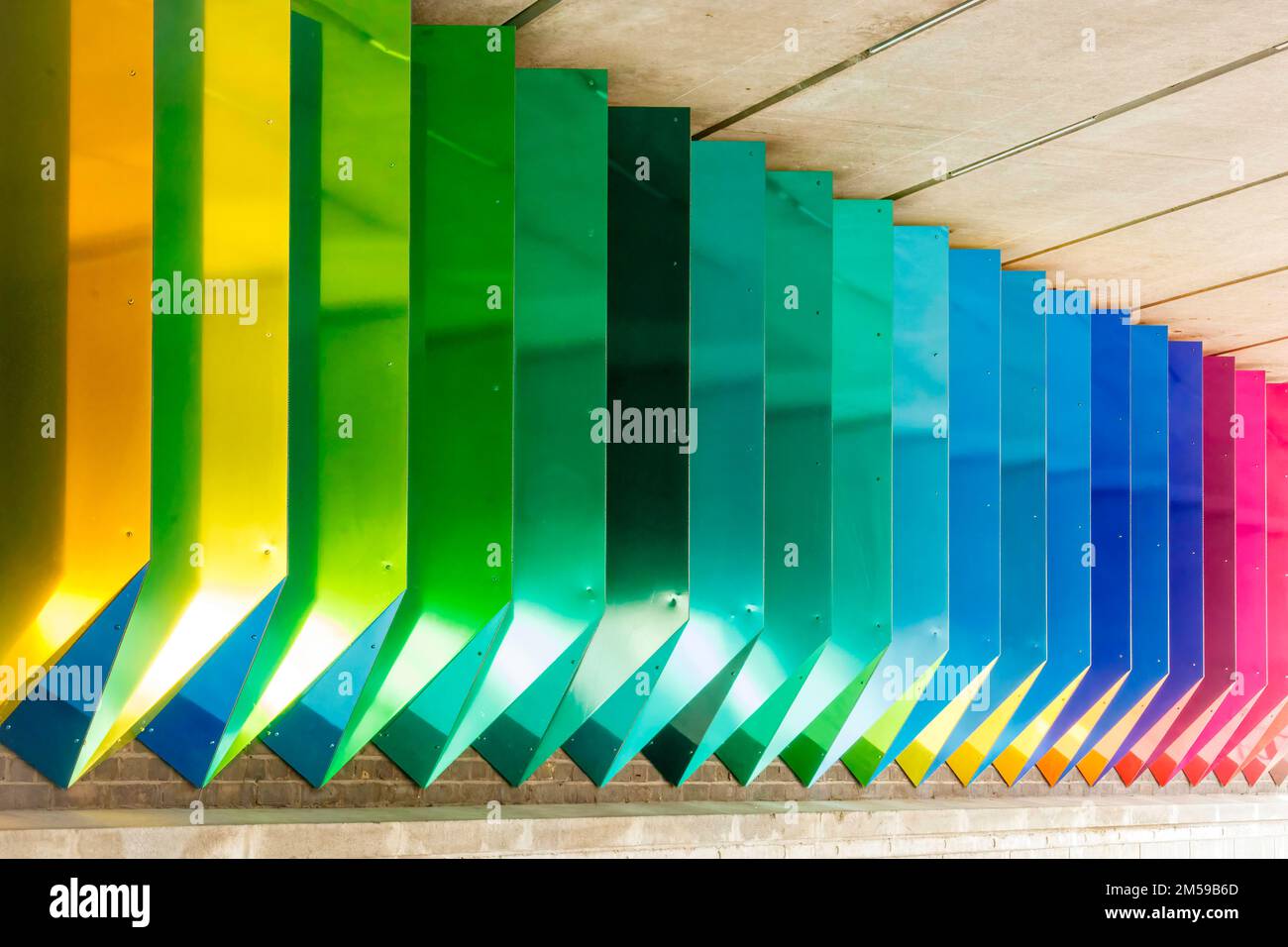 Happy 3D rainbow art, colored tubes made of aluminium and concrete