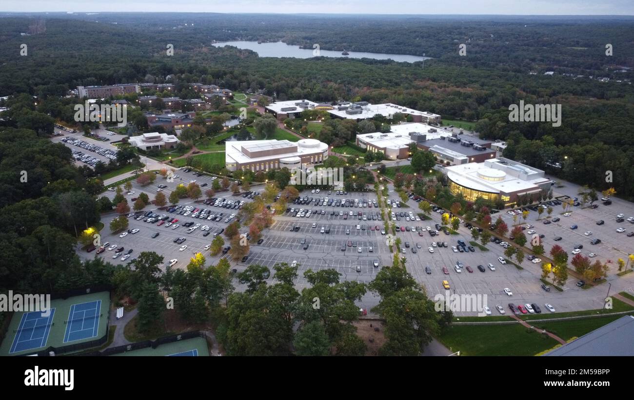 An aerial view of Bryant University and a parking lot with a lake in