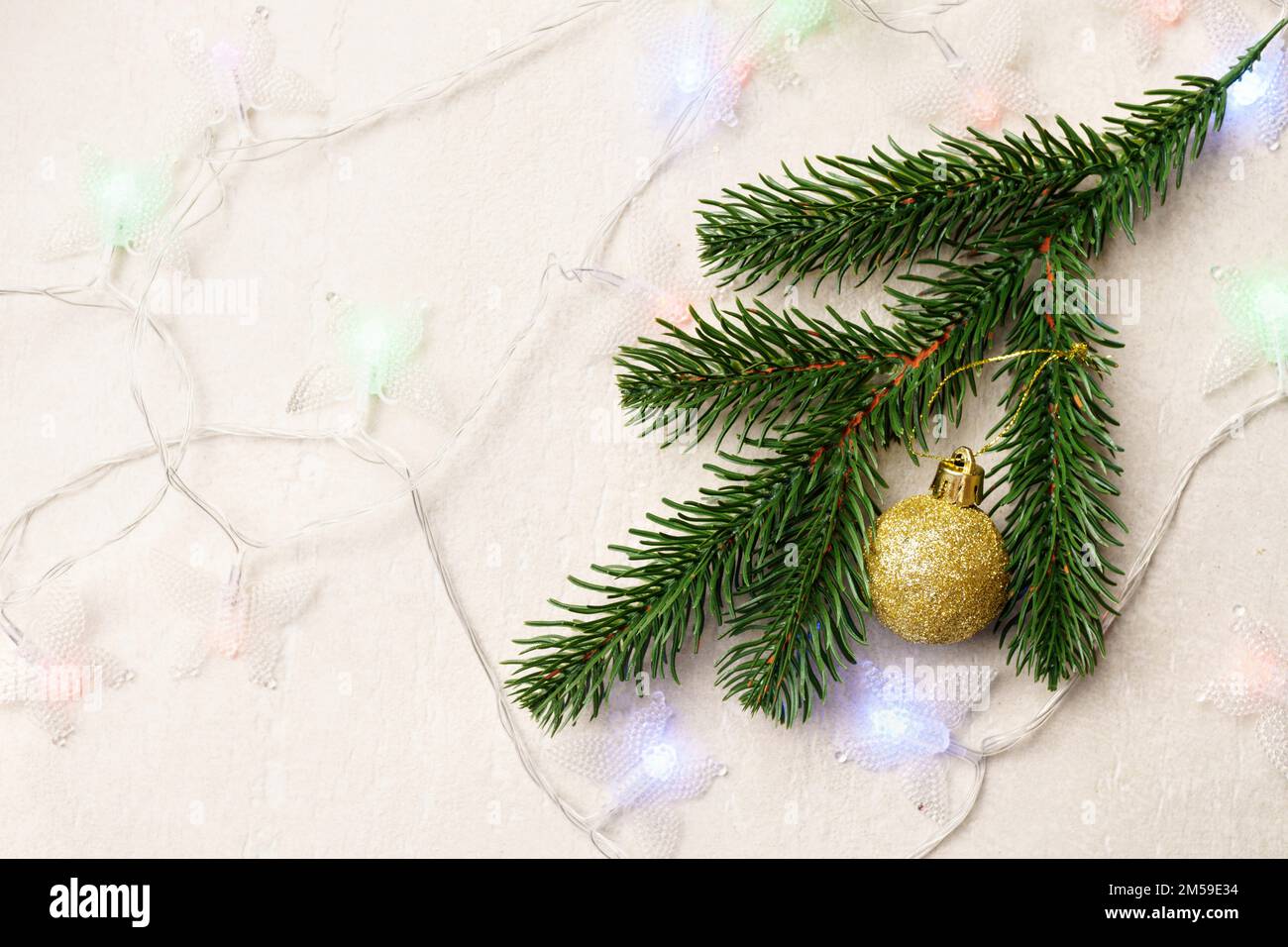 Christmas background with a fir branch and golden balls and a garland ...