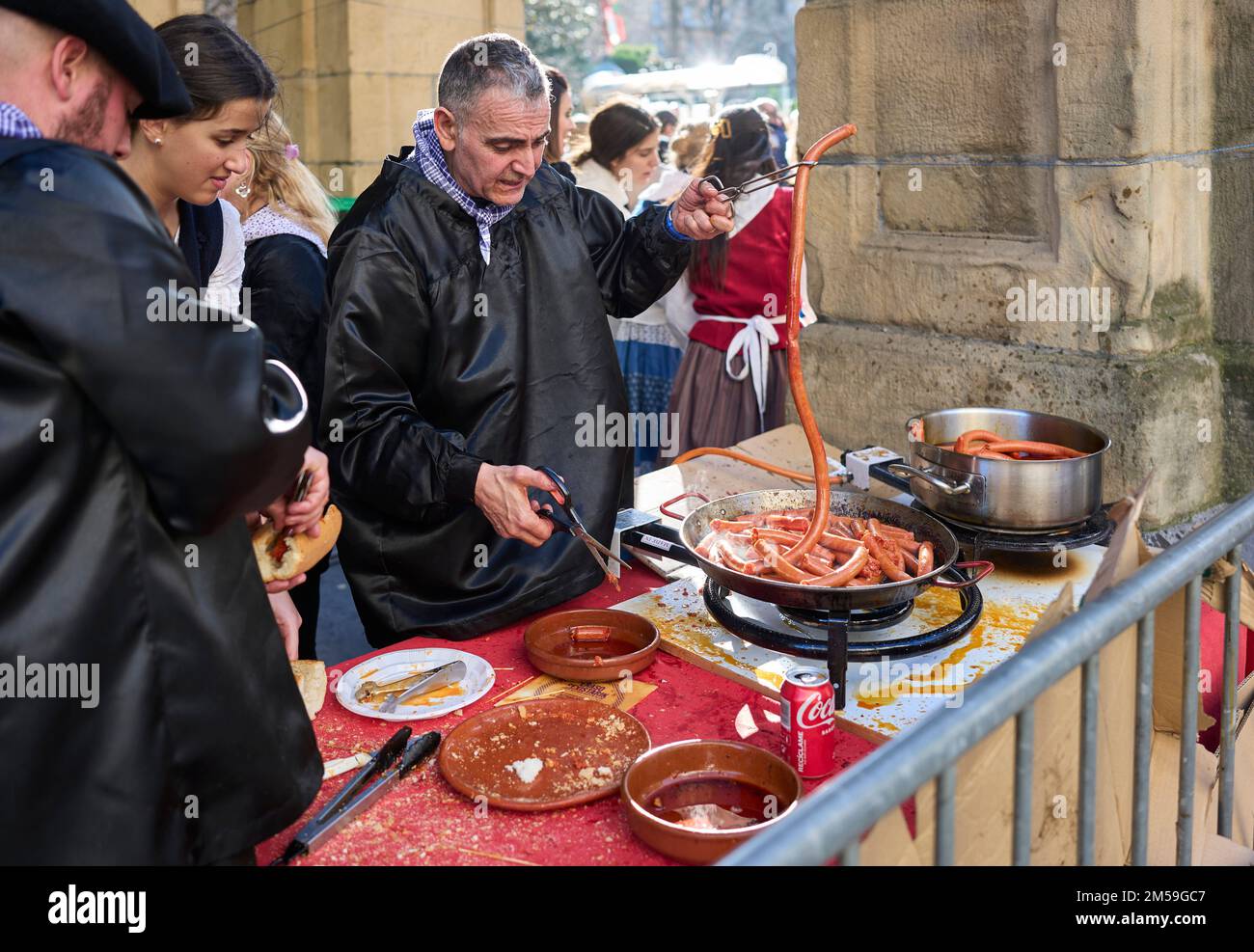 Basque farmers frying Txistorra for the typical street food of the Santo Tomas Fair on Saint Thomas's day, Talos. Stock Photo