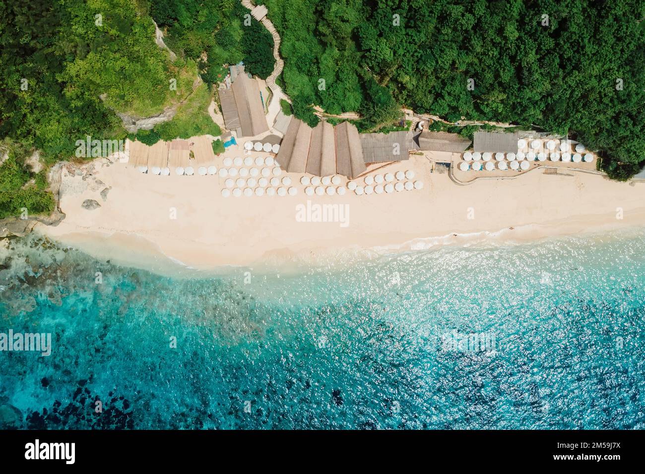 Aerial view of blue ocean and tropical beach with umbrellas in Bali Stock Photo