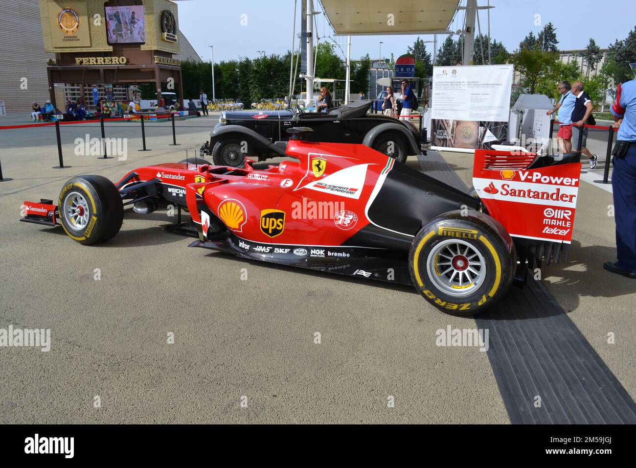 Exposition of the model of Ferrari racing car SF15-T in the Cardo and Decumano main street of Expo Milan 2015 under umbrellas on a  summer sunny day. Stock Photo