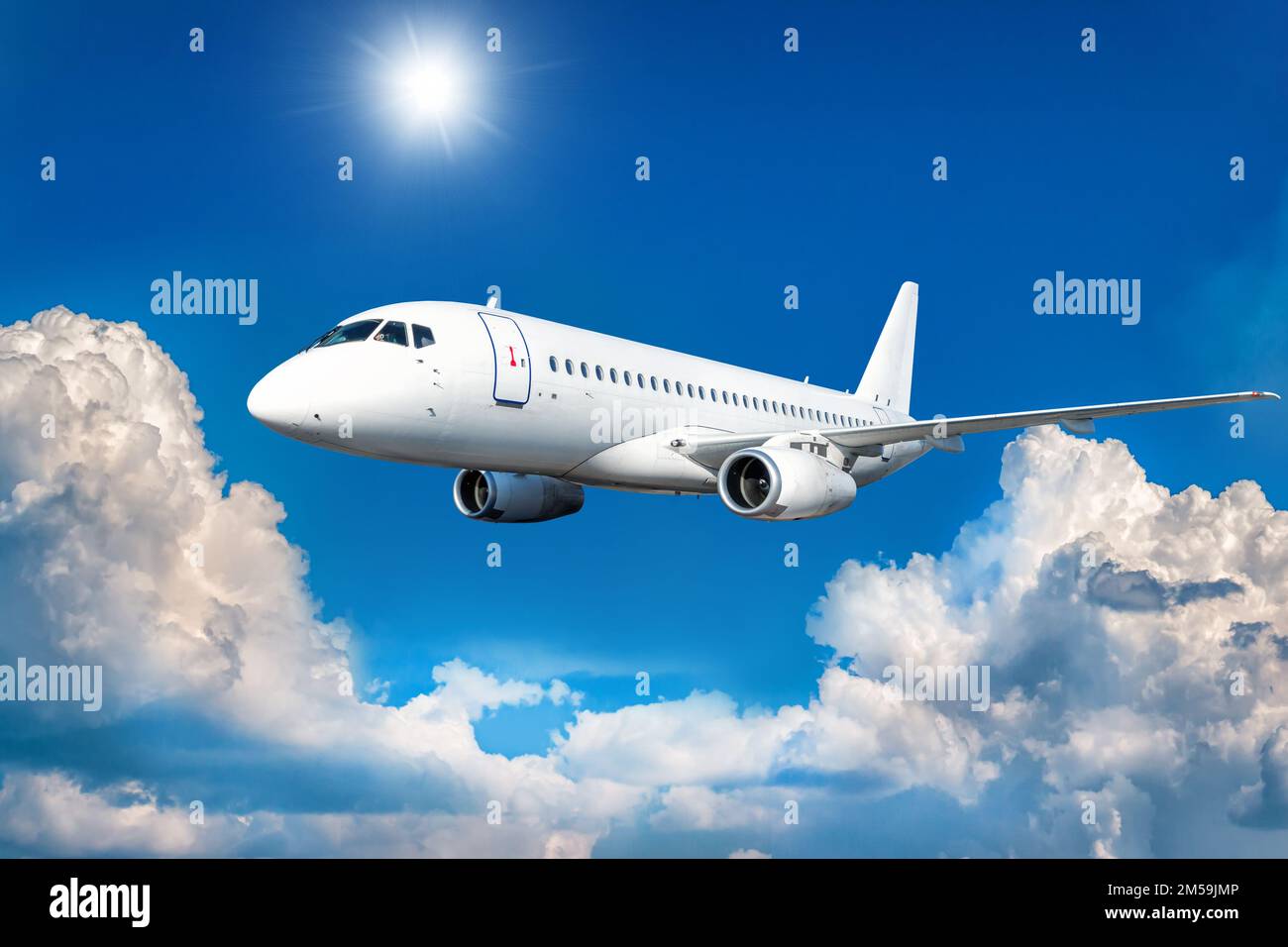 White passenger airliner fly in the air above picturesque clouds Stock ...