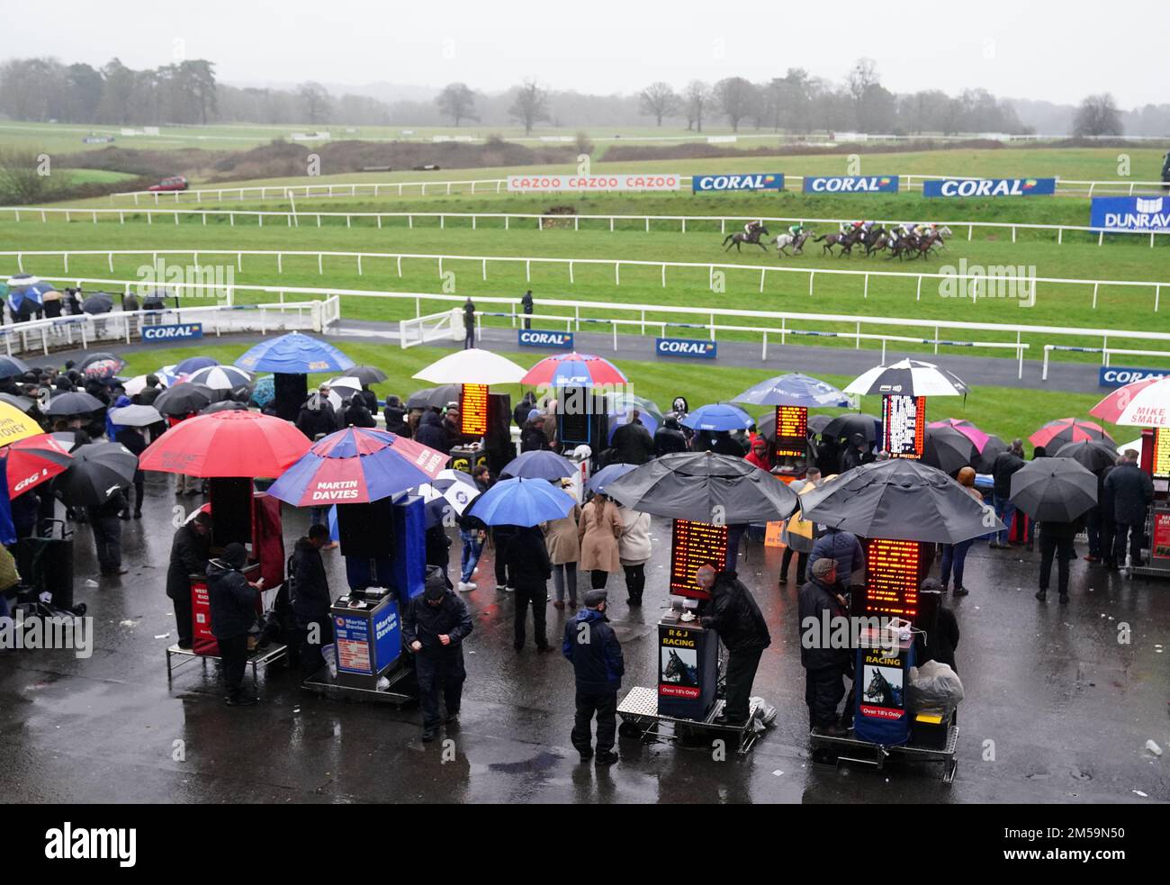 Racegoers and Bookmakers shelter from the rain during the Coral Racing