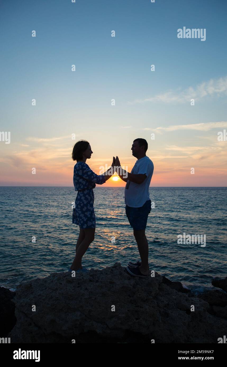 fulllength silhouettes of couple in love, against backdrop of sea and