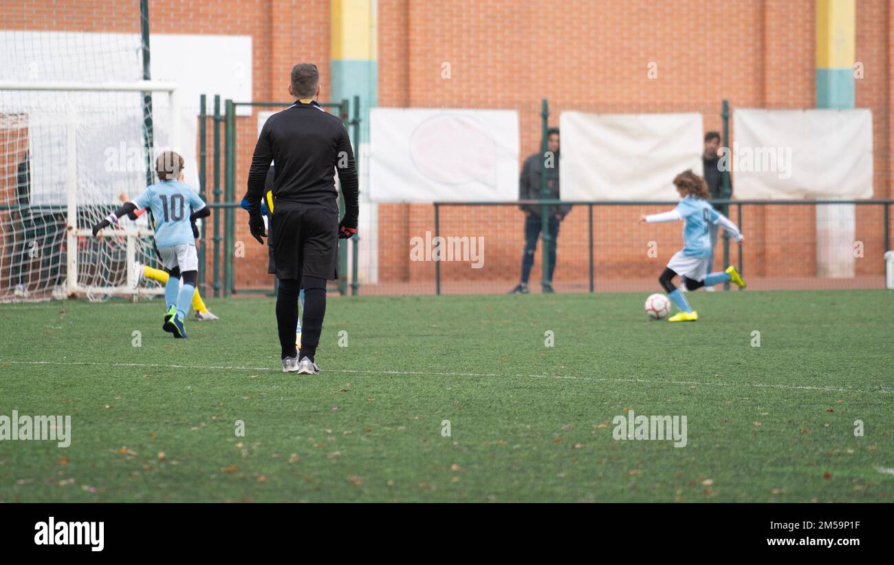 Kids football match. Soccer player run to shoot ball to goal. Concept