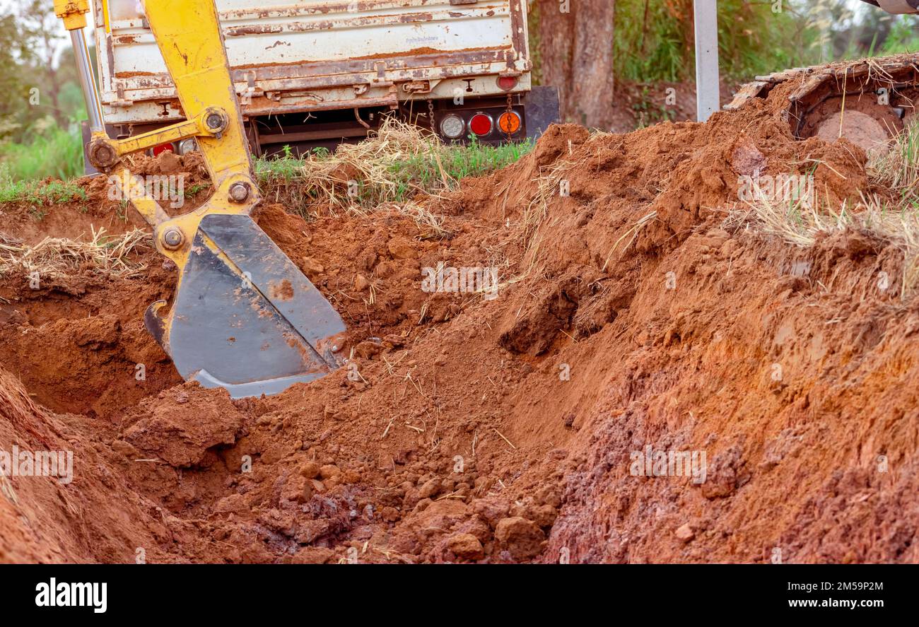 Excavator bucket digging soil for loading to truck. Earthwork. Dirt metal bucket of backhoe