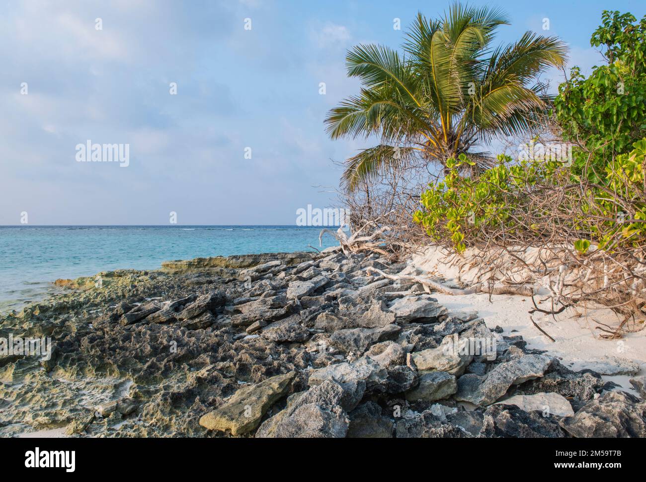 Remote tropical island paradise rocky shoreline with shallow lagoon in