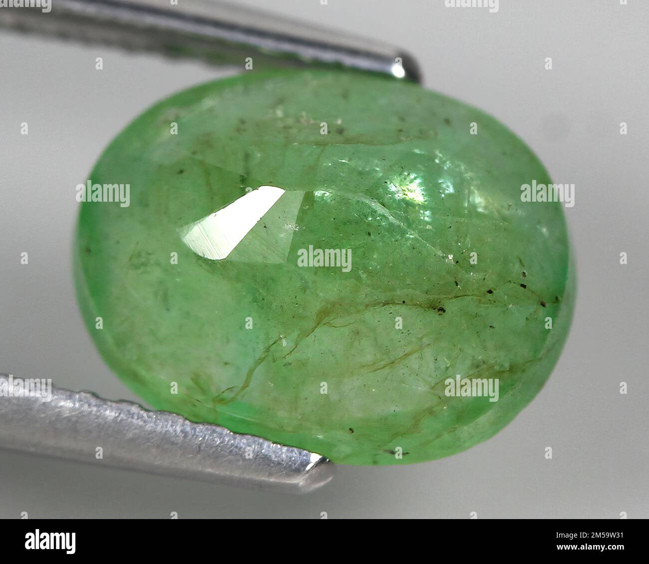 Natural gemstone green emerald on a gray background Stock Photo