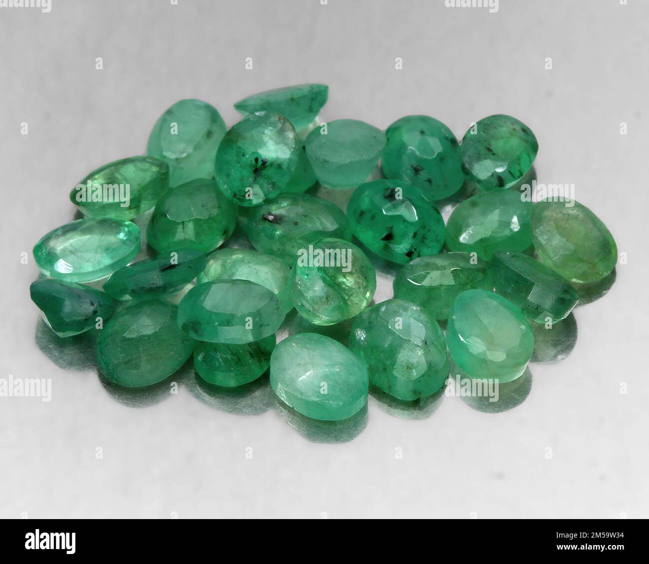 Natural gemstone green emerald on a gray background Stock Photo