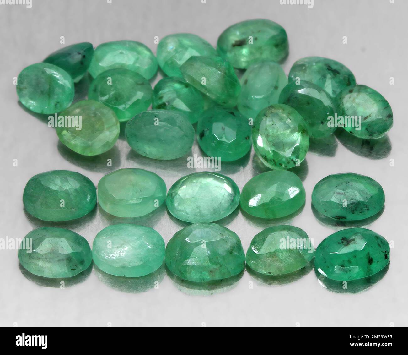 Natural gemstone green emerald on a gray background Stock Photo