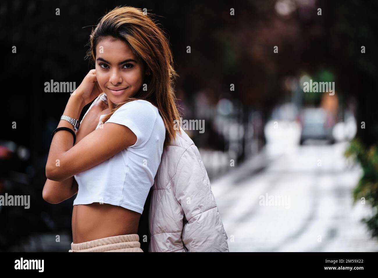 Young Moroccan woman looking at the camera while posing outdoors on the street. Stock Photo
