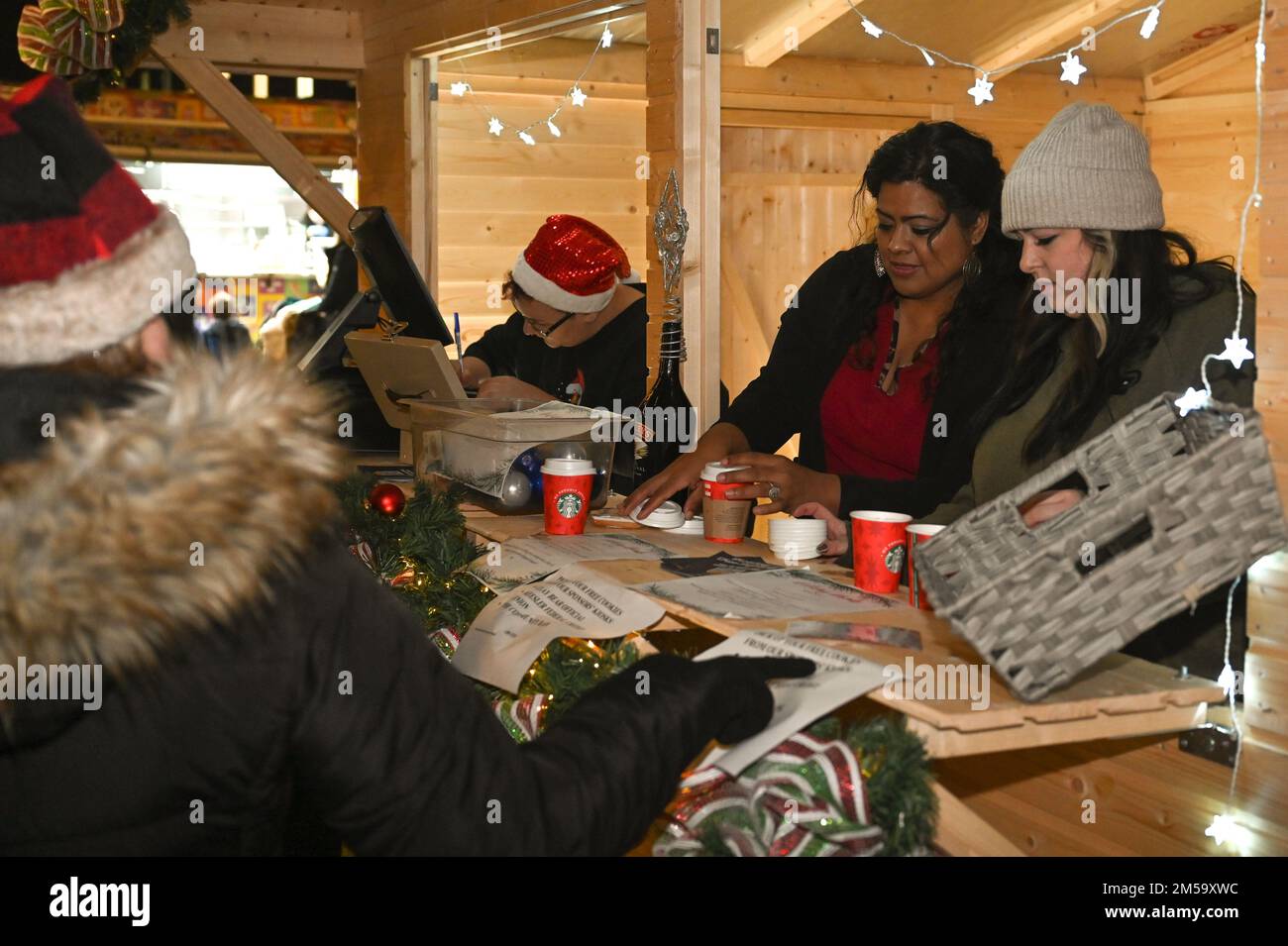 100th Force Support Squadron staff serve hot chocolate to Team Mildenhall families Dec. 1, 2022, at Royal Air Force Mildenhall, England. The hot chocolate was free for all guests that attended the Christmas tree lighting ceremony. Stock Photo