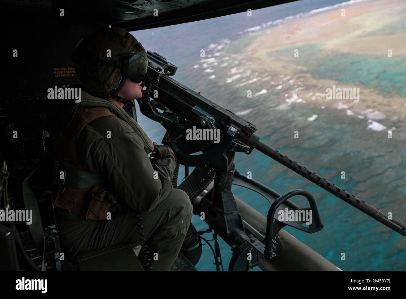A U.S. Marine with Marine Light Attack Helicopter Squadron (HMLA) 369 scans the horizon in a UH-1Y Venom helicopter during a live-fire training event in support of Jungle Warfare Exercise 22 on Ie Shima island, Japan, Feb 15, 2022. JWX 22 is a large-scale field training exercise focused on leveraging the integrated capabilities of joint and allied partners to strengthen all-domain awareness, maneuvers, and fires across a distributed maritime environment. Stock Photo