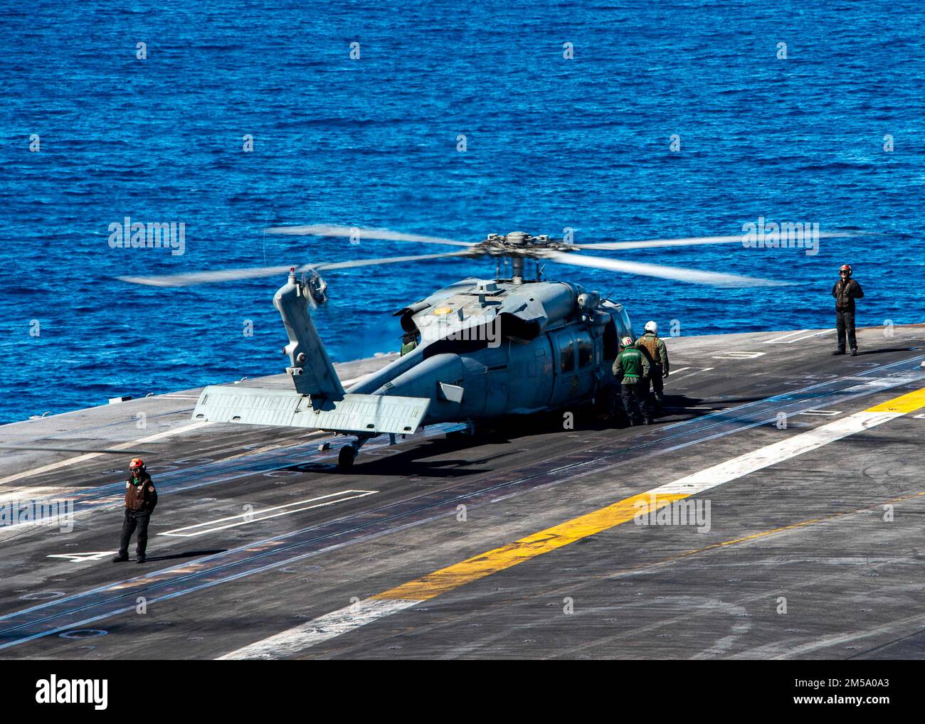 220213-N-MD461-1037 PACIFIC OCEAN (Feb. 13, 2022) An MH-60S Sea Hawk, assigned to the “Black Knights” of Helicopter Sea Combat Squadron (HSC) 4, prepares to take off from the flight deck of Nimitz-class aircraft carrier USS Carl Vinson (CVN 70), Feb. 13, 2022. Vinson is currently conducting routine maritime operations in U.S. 3rd Fleet. Stock Photo