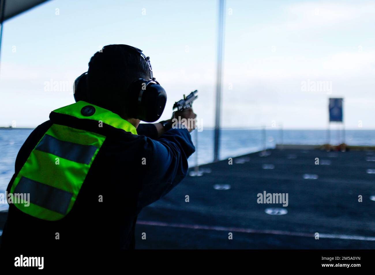 PHILIPPINE SEA (Feb. 13, 2022) Logistics Specialist Seaman Thomas Balderas, from Boerne, Texas, fires an M9 service pistol during a weapons qualification shoot aboard the Nimitz-class aircraft carrier USS Abraham Lincoln (CVN 72). Abraham Lincoln Strike Group is on a scheduled deployment in the U.S. 7th Fleet area of operations to enhance interoperability through alliances and partnerships while serving as a ready-response force in support of a free and open Indo-Pacific region. Stock Photo