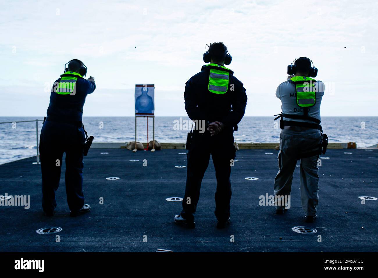 PHILIPPINE SEA (Feb. 13, 2022) Sailors shoot M9 service pistols during a weapons qualification shoot aboard the Nimitz-class aircraft carrier USS Abraham Lincoln (CVN 72). Abraham Lincoln Strike Group is on a scheduled deployment in the U.S. 7th Fleet area of operations to enhance interoperability through alliances and partnerships while serving as a ready-response force in support of a free and open Indo-Pacific region. Stock Photo