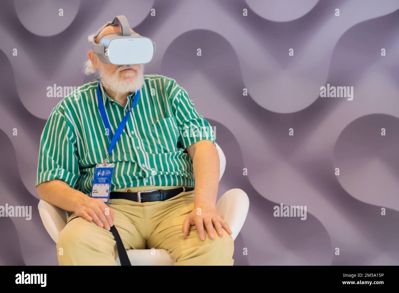 Elderly man using virtual reality headset at VR exhibition Stock Photo