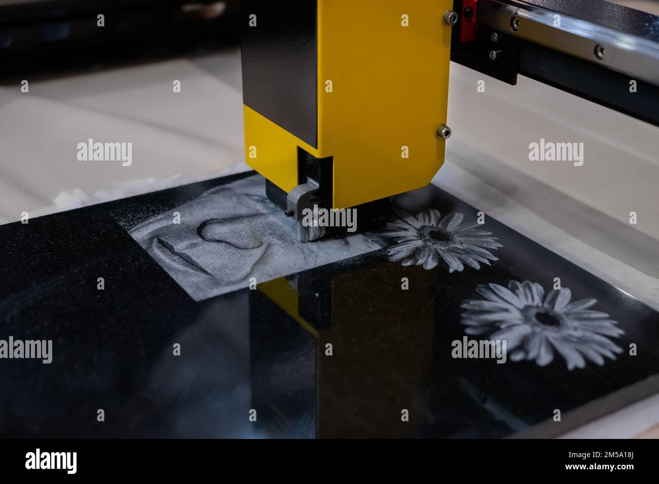 Stone engraving machine etching portrait on black granite gravestone close up Stock Photo Alamy