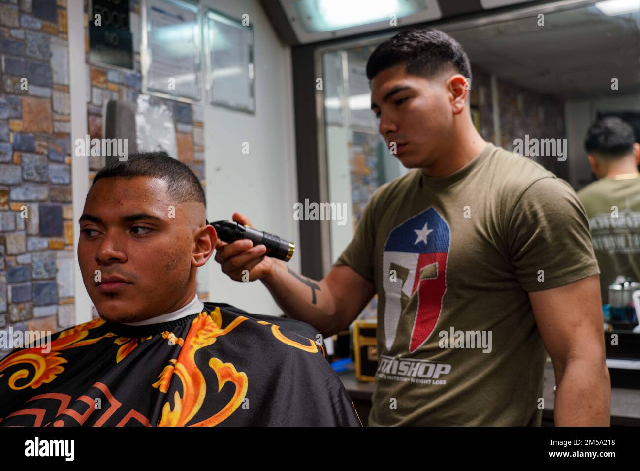 PACIFIC OCEAN (Feb. 13, 2022) Operations Specialist 2nd Class Juan Gonzalez, left, a native of Huntington Station, N.Y., get a haircut from Marine Corps Cpl. Jose Soriano, right, a field artillery cannoneer, assigned to 1/1 Bravo Battery, 11th Marine Expeditionary Unit (MEU), a native of Fort Worth, Texas, in the ship’s hair salon aboard Harpers Ferry-class amphibious dock landing ship USS Pearl Harbor (LSD 52), in the Pacific Ocean, Feb. 13, 2022. Pearl Harbor, part of the Essex Amphibious Ready Group (ARG), along with the 11th MEU, is operating in the U.S. 7th Fleet area of operations to enh Stock Photo