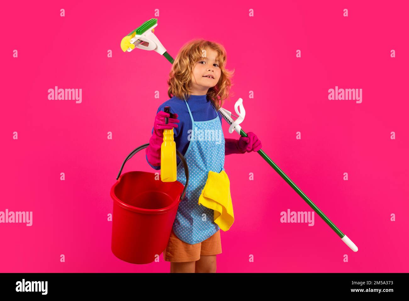 Portrait of child cleaning, concept growth, development, family relationships. Housekeeping and home cleaning concept. Child use duster and gloves for Stock Photo