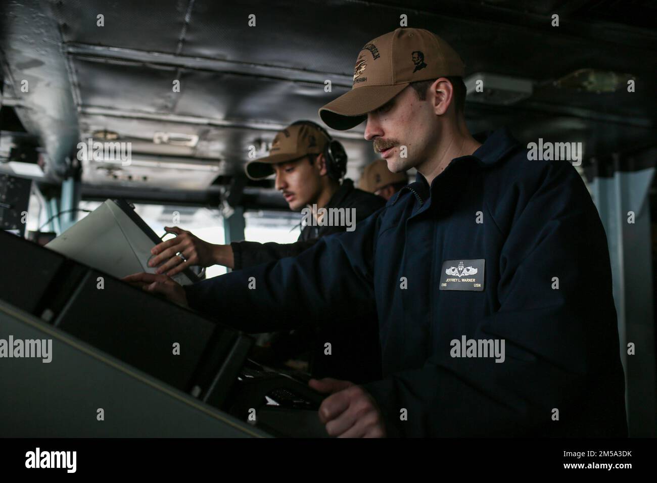 PHILIPPINE SEA (Feb. 14, 2022) Ensign Jeffrey Warner, right, from Coldwater, Mich., monitors a radar for surface or air contacts on the bridge aboard the Nimitz-class aircraft carrier USS Abraham Lincoln (CVN 72). Abraham Lincoln Strike Group is on a scheduled deployment in the U.S. 7th Fleet area of operations to enhance interoperability through alliances and partnerships while serving as a ready-response force in support of a free and open Indo-Pacific region. Stock Photo
