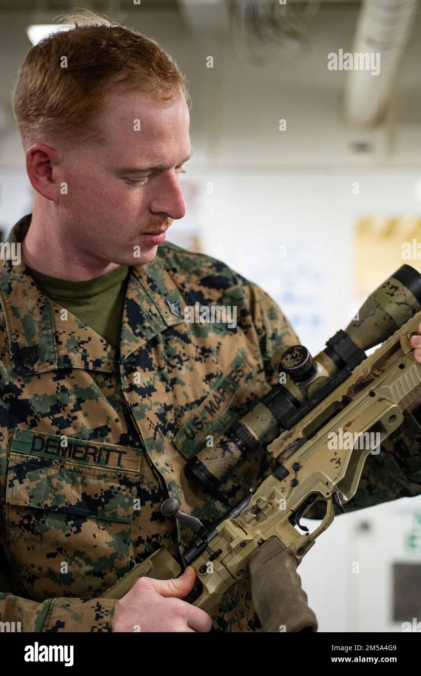 PHILIPPINE SEA (Feb. 14, 2022) Sergeant Brennon DeMeritt, from Watkins Glen, N.Y., assigned to the 31st Marine Expeditionary Unit (MEU), conducts weapons maintenance in the troop marshalling area of the forward-deployed amphibious assault ship USS America (LHA 6). America, lead ship of America Amphibious Ready Group, along with the 31st MEU, is operating in the U.S. 7th Fleet area of responsibility to enhance interoperability with allies and partners and serve as a ready response force to defend peace and stability in the Indo-Pacific region. Stock Photo