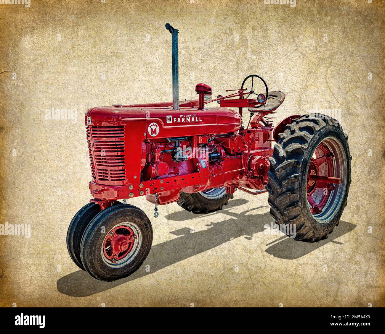 A 1950s era McCormick International Harvester Farmall Model Super M red tractor in a mixed-media photograph overlaid on a textured antique background. Stock Photo